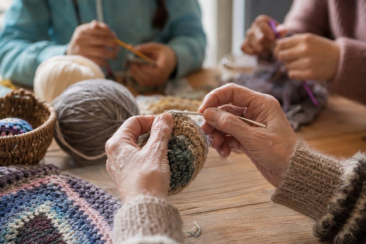 Close-up of hands crocheting with blue yarn at the community hub.