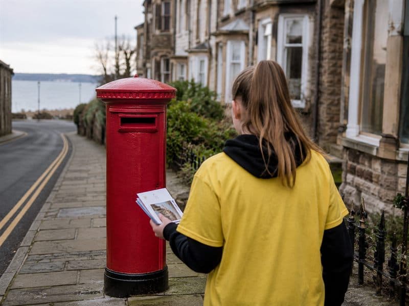 A kindness post box with blank postcards beside it.