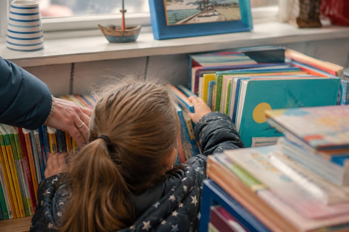 A stack of well-read children's books on a wooden table.