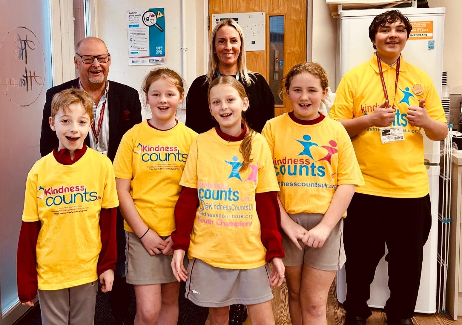 Five youth champions in their yellow Kindness Counts UK t-shirts with our president John Cross and a member of school staff.