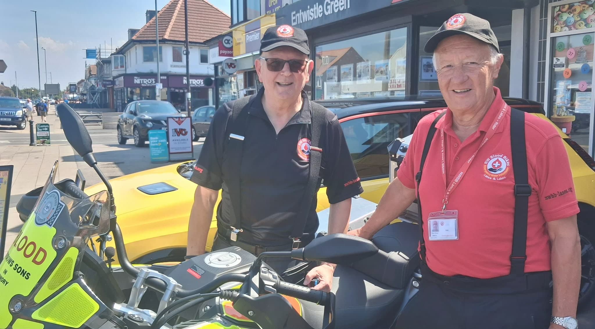 Two North West Blood Bikes volunteers with their motorbike outside the hub.