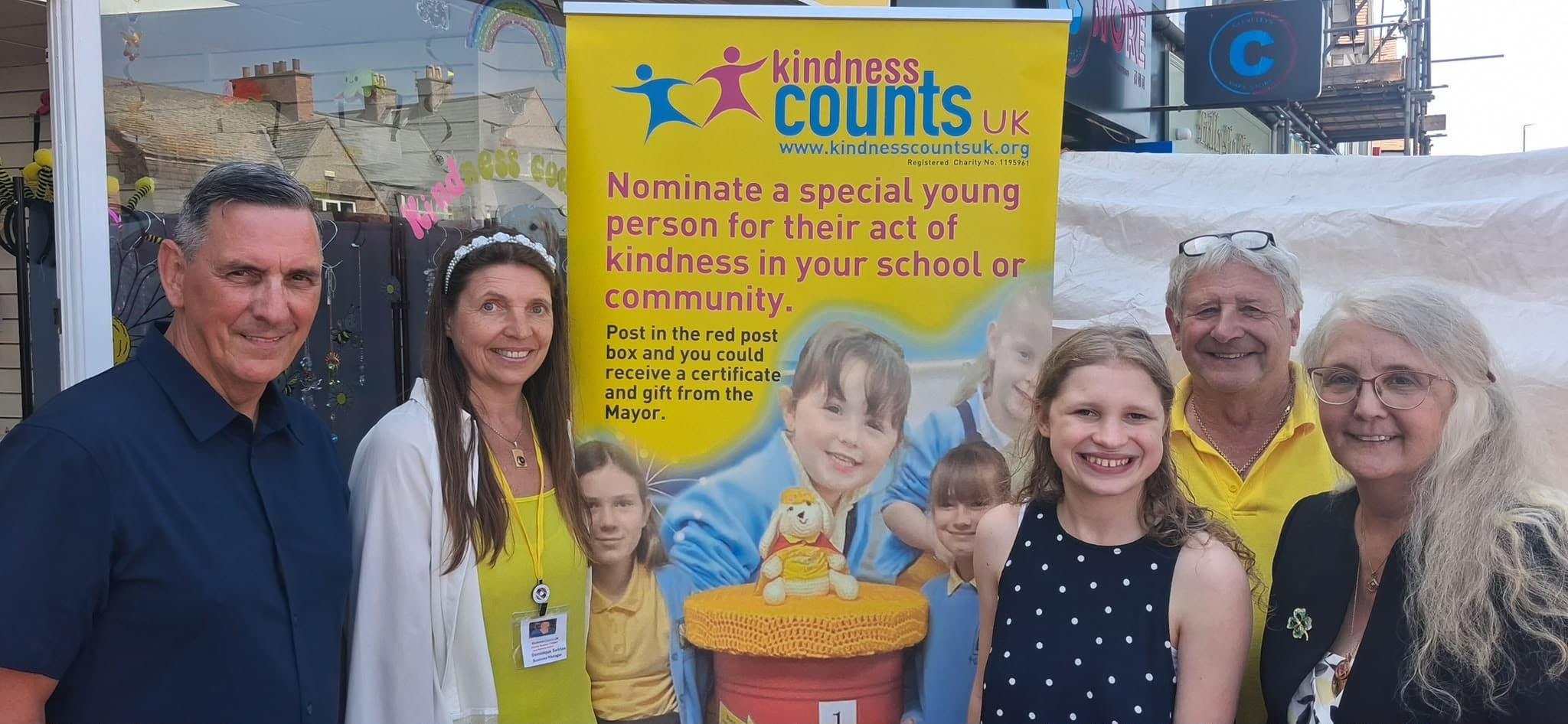 The team beside the Kindness Counts UK banner outside the new hub.