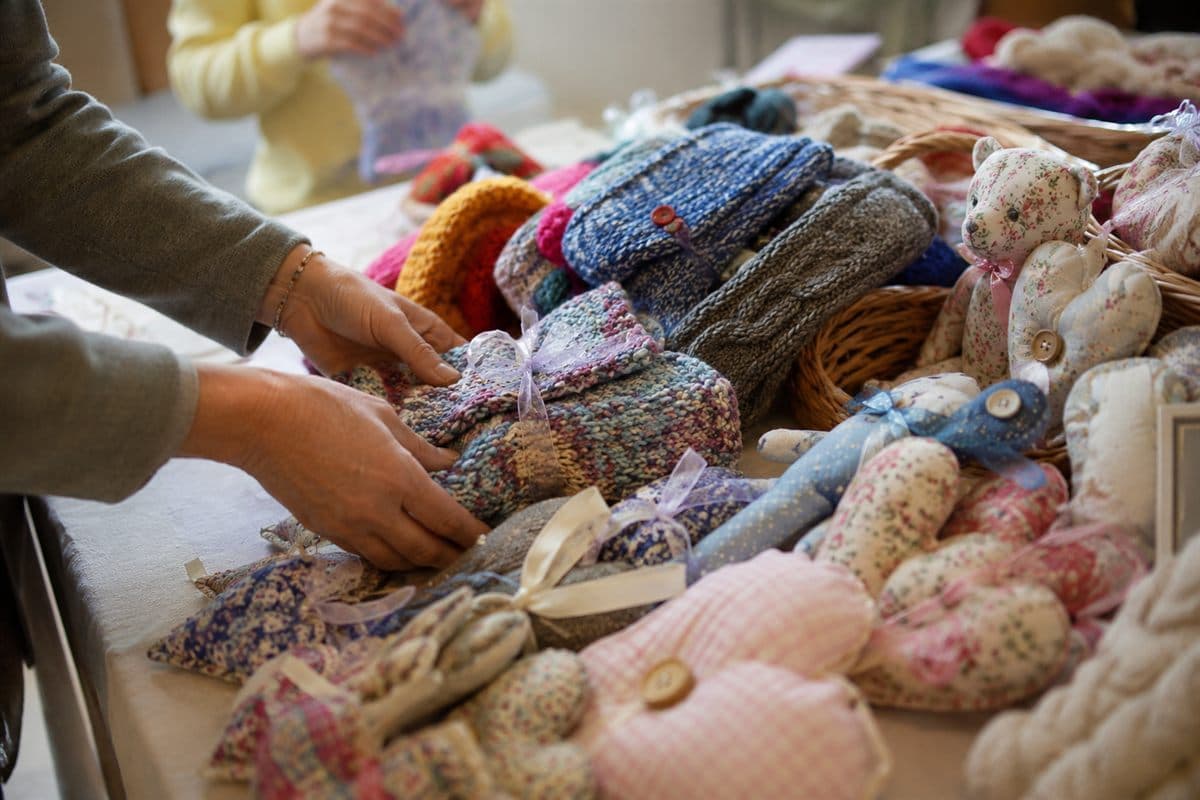 Handmade knitted and crocheted items arranged on a shelf.